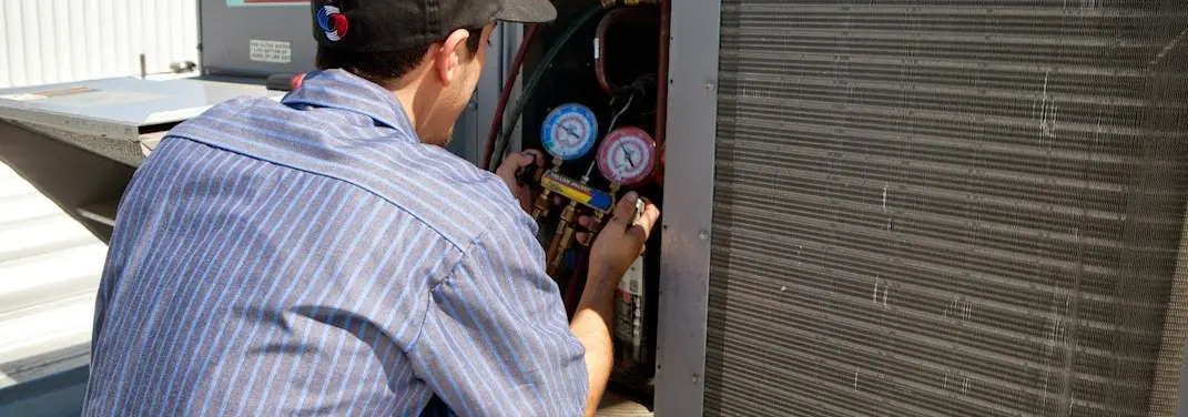 HVAC technician servicing a condenser unit in Bridgeport
