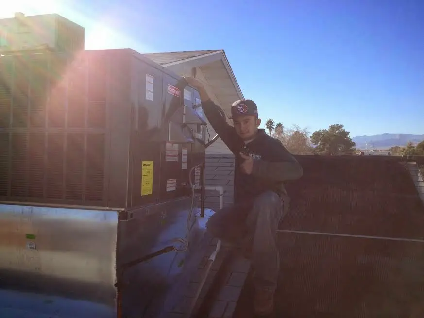 HVAC technician performing AC Tune-Up on a rooftop unit in Bridgeport
